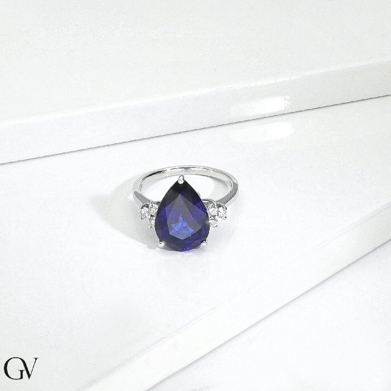 Ring in white gold 18k with central blue sapphire drop cut and three diamonds per side