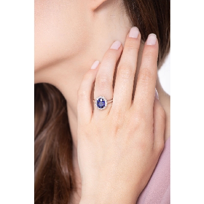 White gold 18k halo ring with a central blue sapphire and diamonds 