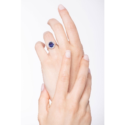 White gold 18k halo ring with a central blue sapphire and diamonds 