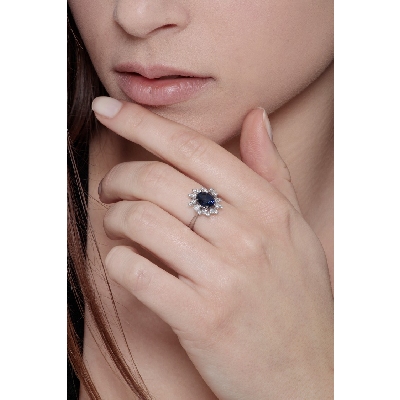 White gold 18k diamond halo ring with a central blue sapphire