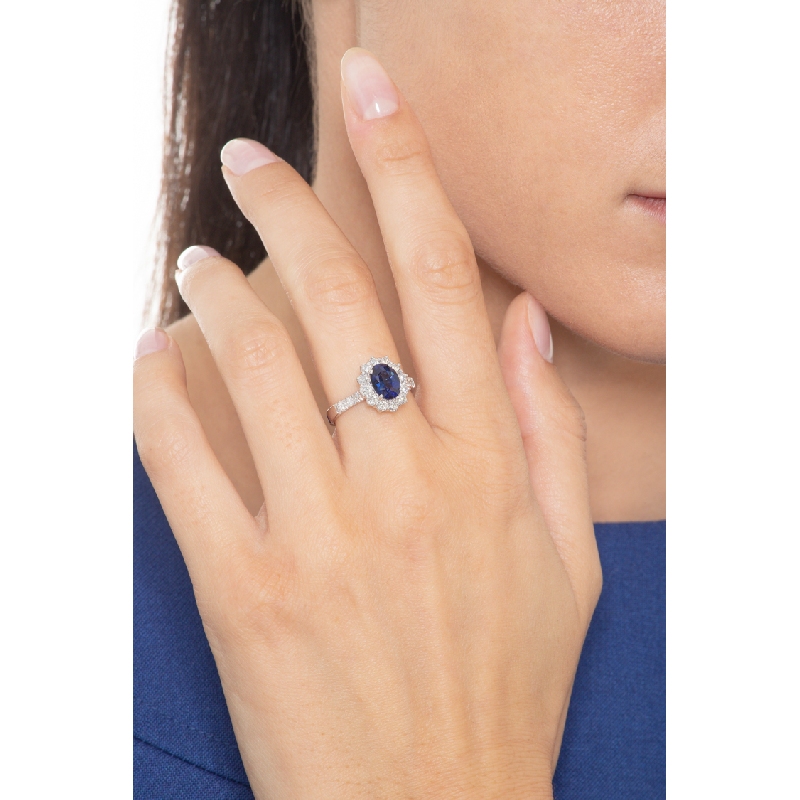 White gold 18k halo ring with blue sapphire and diamond shoulder set 