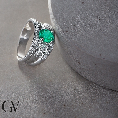 Band ring with a central emerald and diamonds in white gold 18k