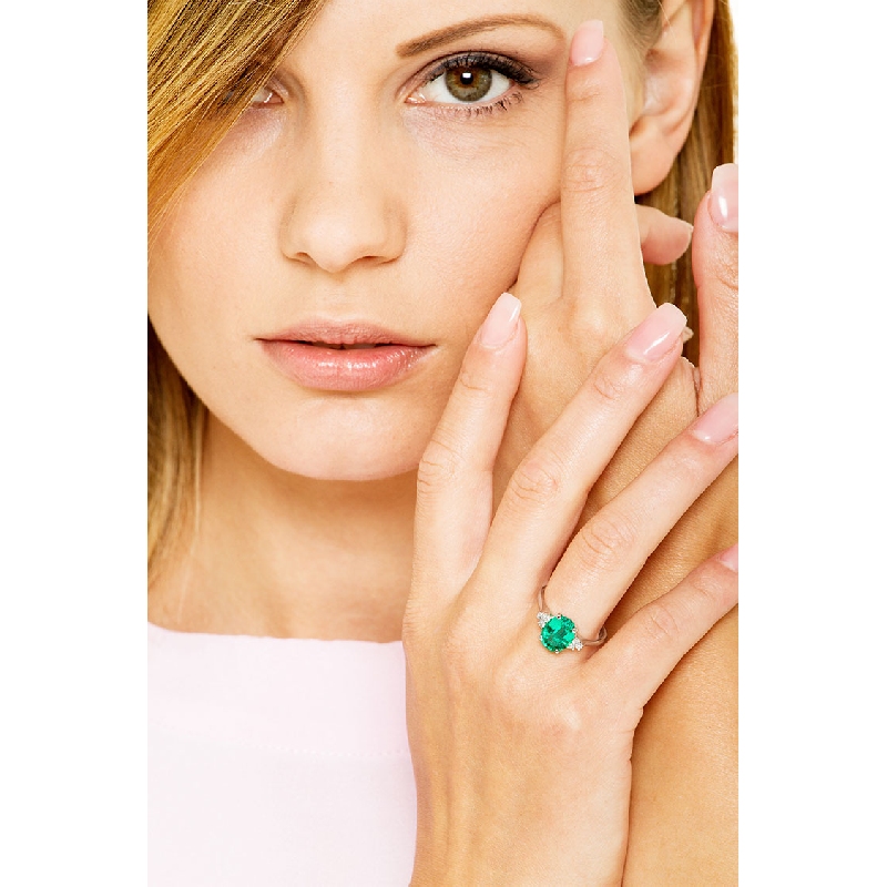 Ring with central emerald oval cut and lateral diamonds 