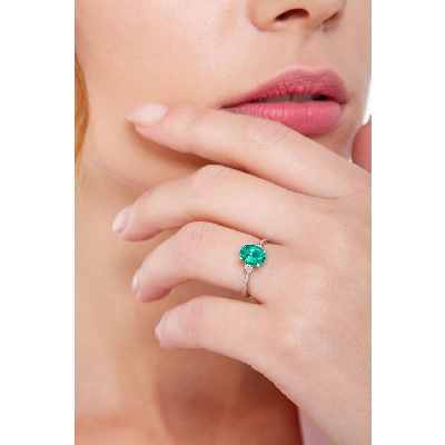 White gold 18k ring with emerald and one diamond on each side