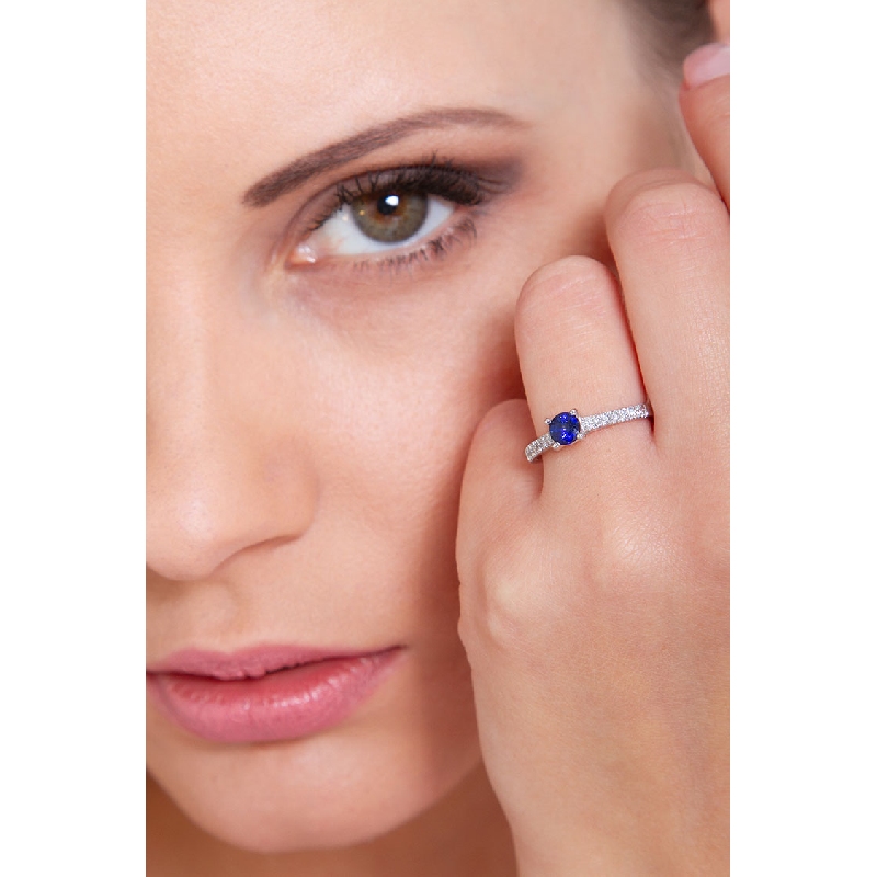 18k white gold with a central blue sapphire and diamonds shoulder set