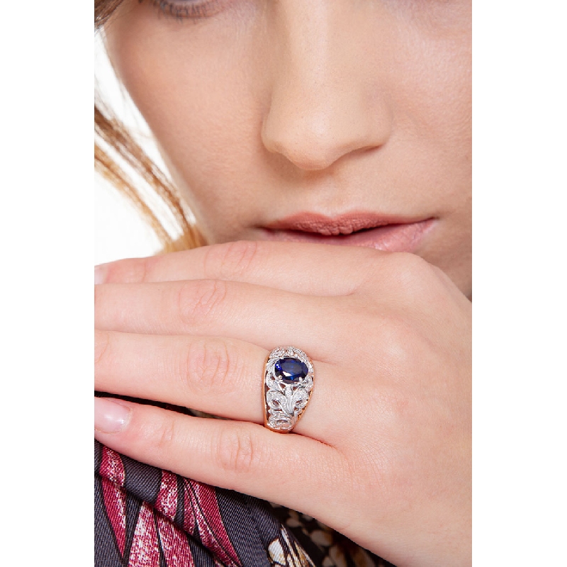 18k white and rosé gold with a central blue sapphire and diamonds 