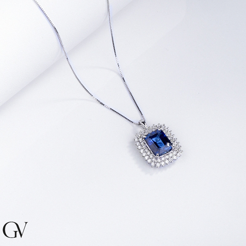 Necklace with pendant, central emerald cut blue sapphire and round cut diamonds
