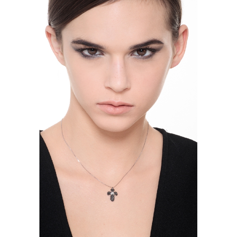 Rounded cross pendant with black diamonds and a solitaire diamond