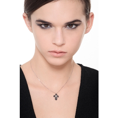 Rounded cross pendant with black diamonds and a solitaire diamond