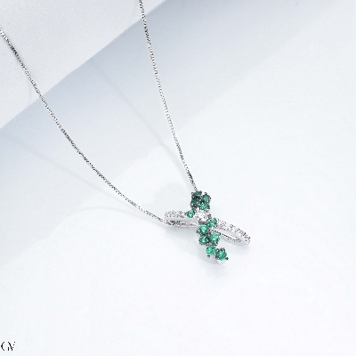 Necklace with fancy twisted pendant with emeralds and diamonds
