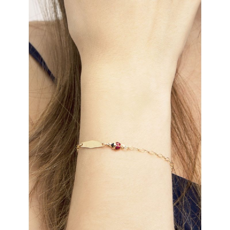 Bracciale in oro giallo 18k con coccinelle e piastrina incidibile.