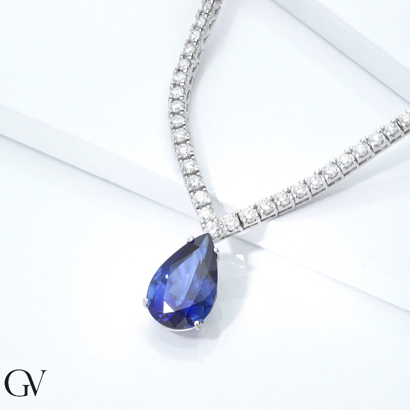 Gradueted tennis chain in 18k white gold with a big  pear cut blue sapphire and diamonds