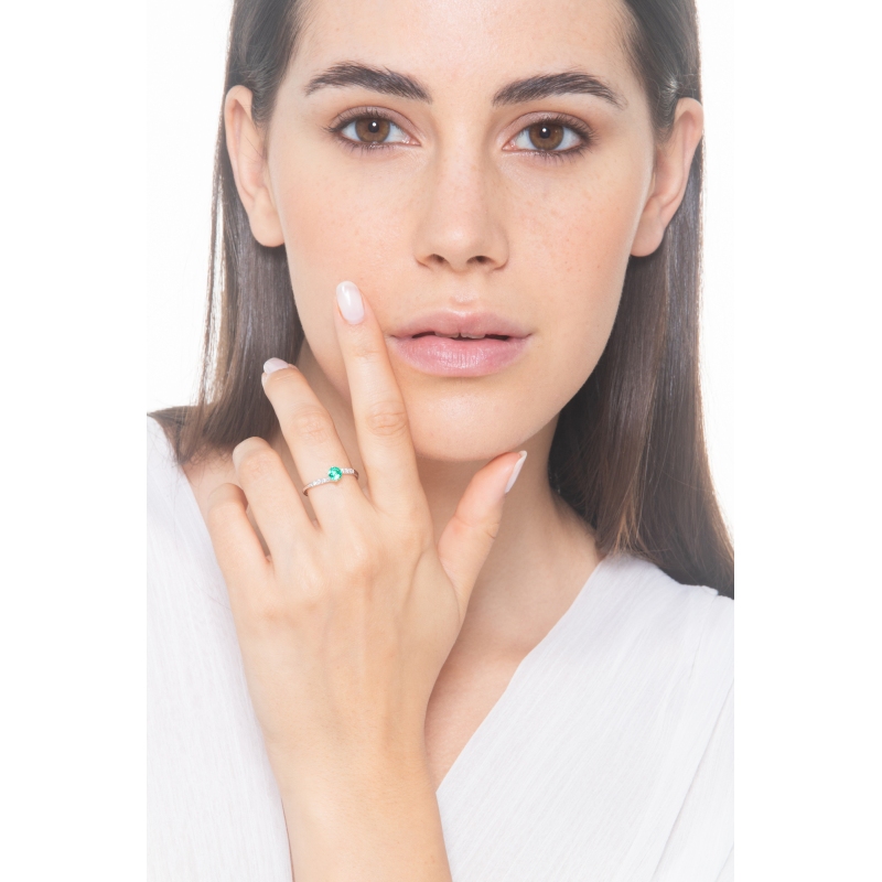Ring with a central emerald and diamonds on an irregular shank 