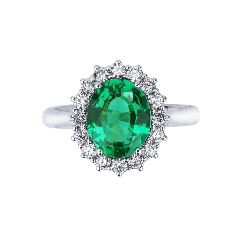 Halo ring with oval cut central emerald and diamonds in white gold 18k
