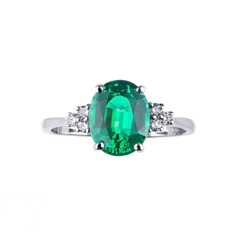Ring with central emerald oval cut and lateral diamonds 