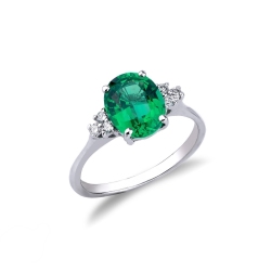 Ring with central emerald oval cut and lateral diamonds 