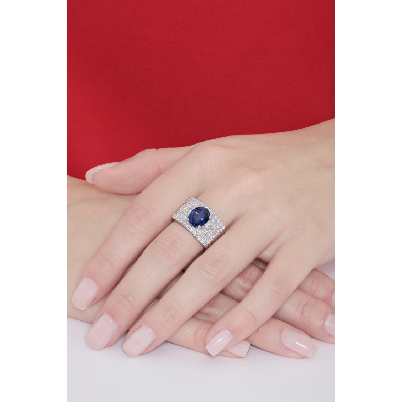 Band ring with a central blue sapphire oval cut and diamonds