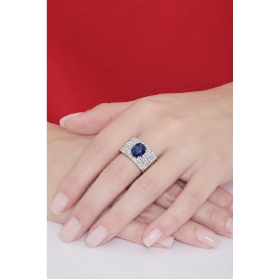 Band ring with a central blue sapphire oval cut and diamonds