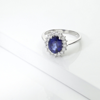 Anello contorno in oro bianco 18k con zaffiro ovale blu e diamanti