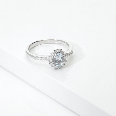 Anello in oro bianco 18k con acquamarina ovale e halo di diamanti
