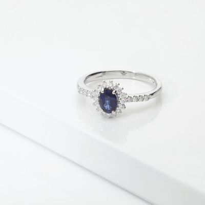 Anello in oro bianco 18k con zaffiro ovale e halo di diamanti