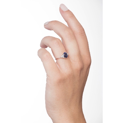White gold 18k ring with three diamonds on both sides and blue sapphire