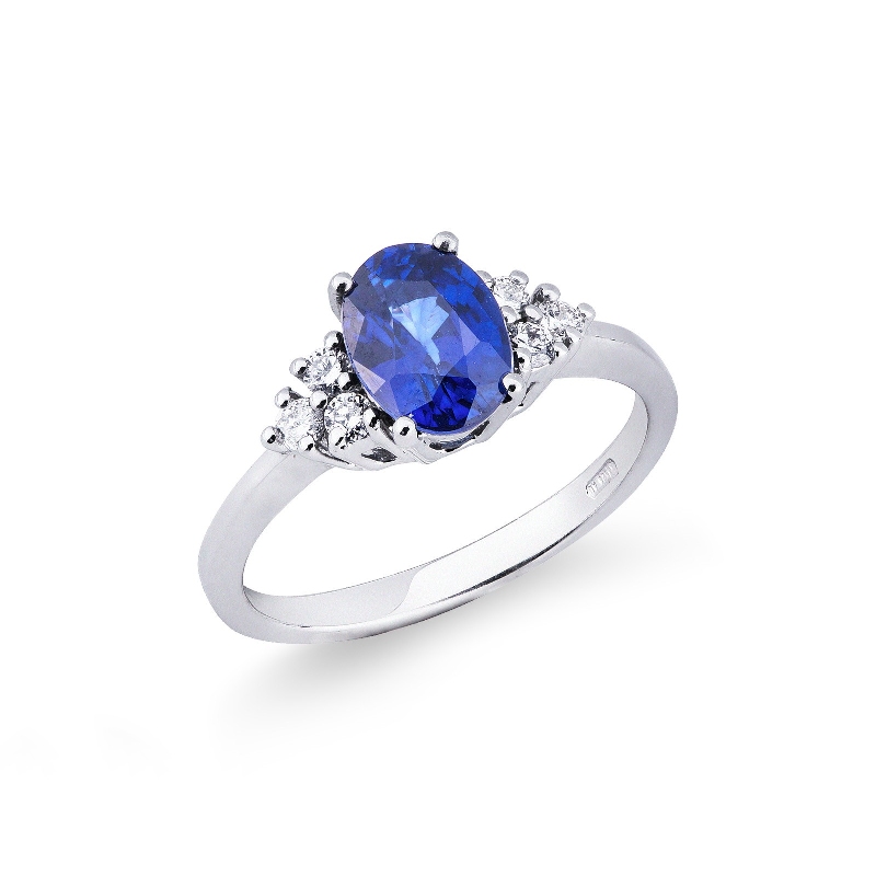 White gold 18k ring with three diamonds on both sides and blue sapphire