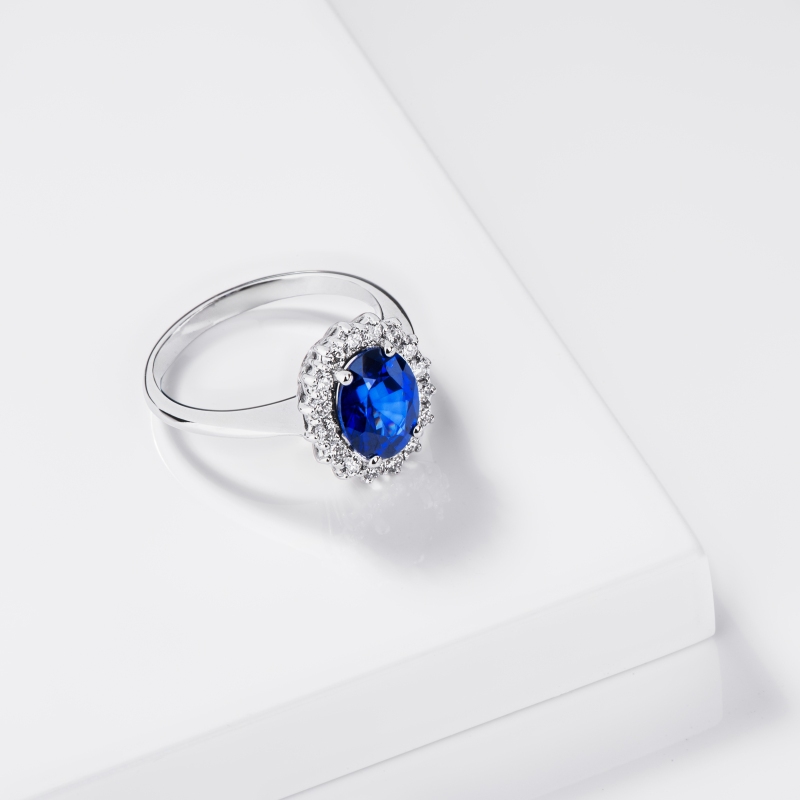 Anello contorno in oro bianco 18k con zaffiro ovale blu e diamanti