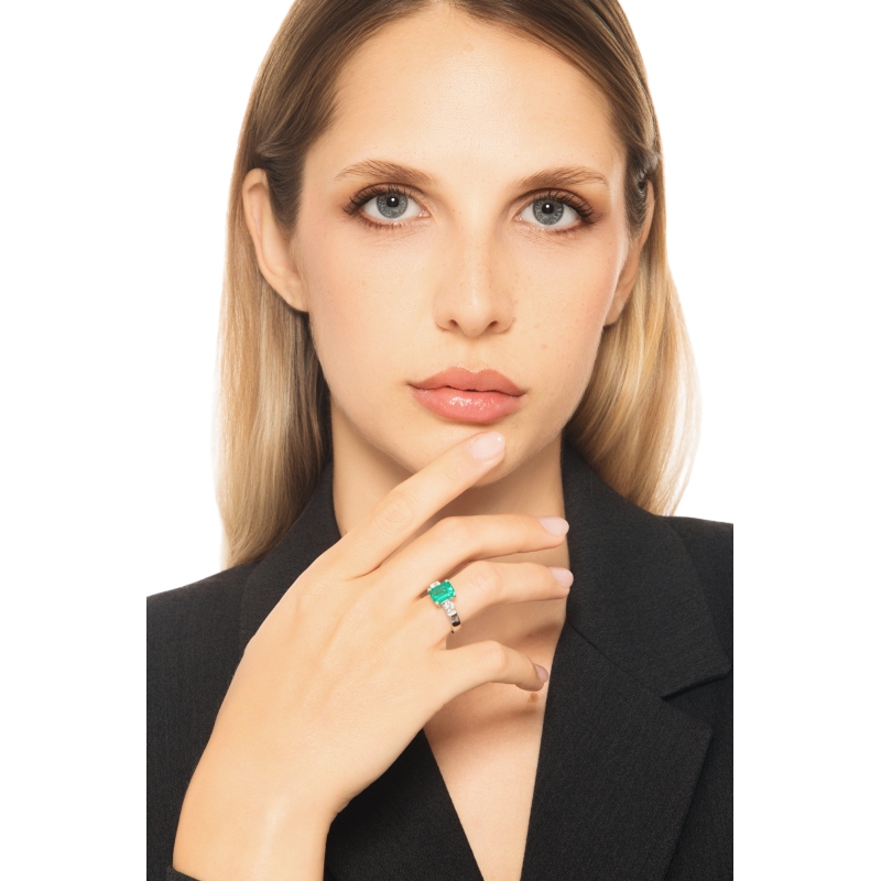 18k white gold ring with a central emerald and side diamonds 