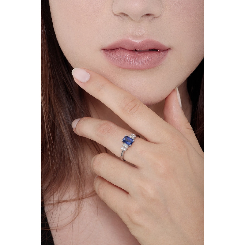 Ring with a blue sapphire emerald cut and four diamonds on each side 